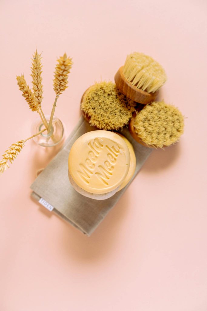 Eco-friendly cleaning brushes and soap on a pink background, perfect for sustainable living themes.